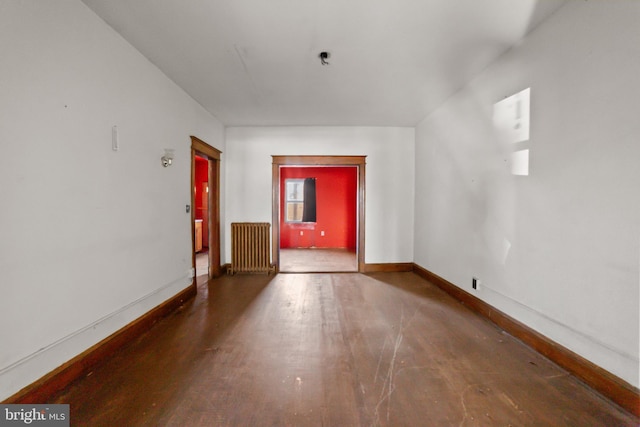 additional living space with radiator and dark hardwood / wood-style floors