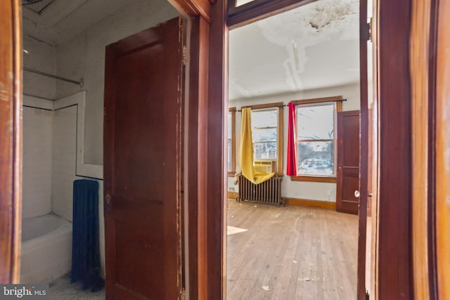 corridor with radiator and light hardwood / wood-style floors