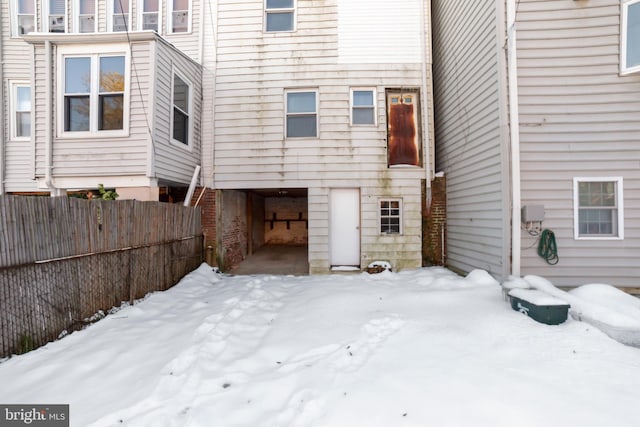 view of snow covered back of property