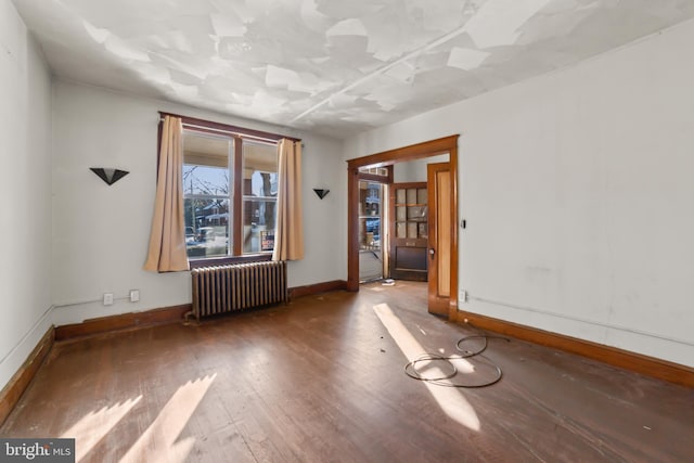 spare room with hardwood / wood-style flooring and radiator heating unit