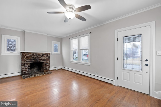 entryway featuring ceiling fan, ornamental molding, a fireplace, and a baseboard radiator