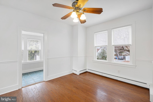 empty room featuring hardwood / wood-style flooring, plenty of natural light, ceiling fan, and a baseboard radiator