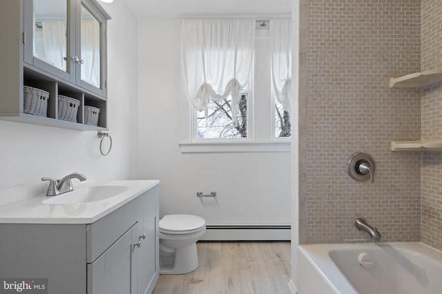 full bathroom featuring vanity, a baseboard radiator, hardwood / wood-style floors, toilet, and tiled shower / bath