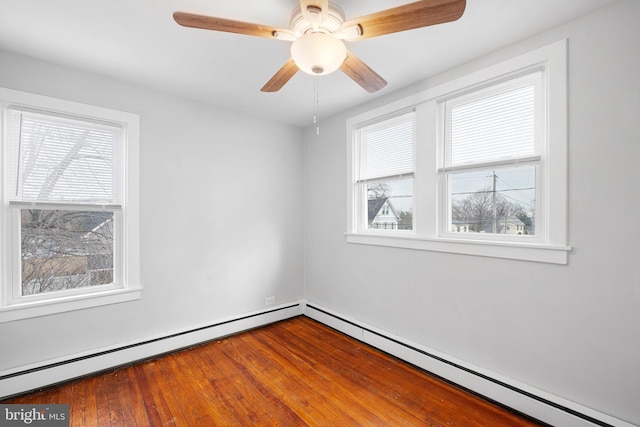 spare room with ceiling fan, a healthy amount of sunlight, and wood-type flooring