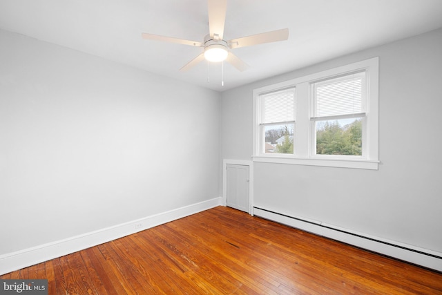 unfurnished room with ceiling fan, hardwood / wood-style floors, and a baseboard heating unit