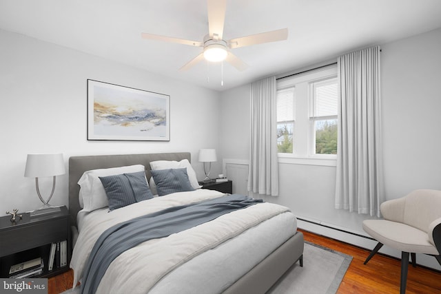 bedroom with hardwood / wood-style flooring, ceiling fan, and baseboard heating