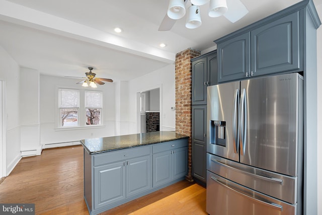 kitchen with stainless steel refrigerator with ice dispenser, ceiling fan, dark stone countertops, light hardwood / wood-style floors, and kitchen peninsula