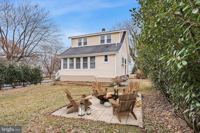 back of house featuring a yard, an outdoor fire pit, and a patio area