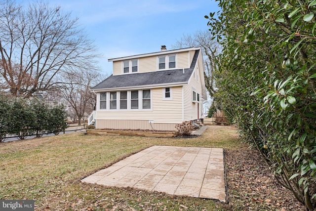 back of property with a lawn and a patio area