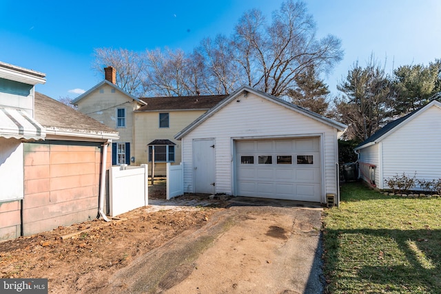 view of front of home featuring an outbuilding, a garage, and a front lawn