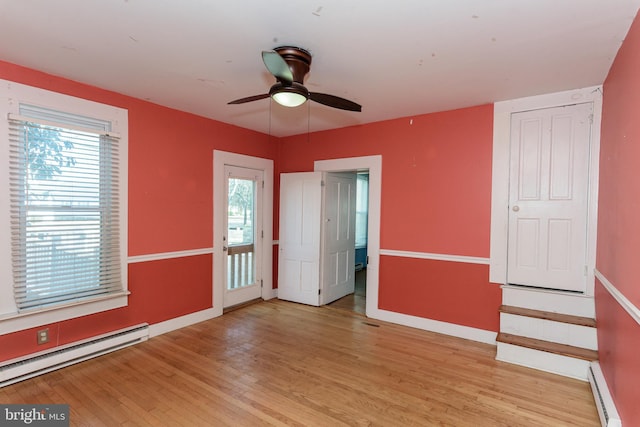 unfurnished room featuring a baseboard radiator, light hardwood / wood-style floors, and ceiling fan