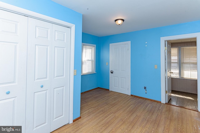 unfurnished bedroom featuring light wood-type flooring and a closet