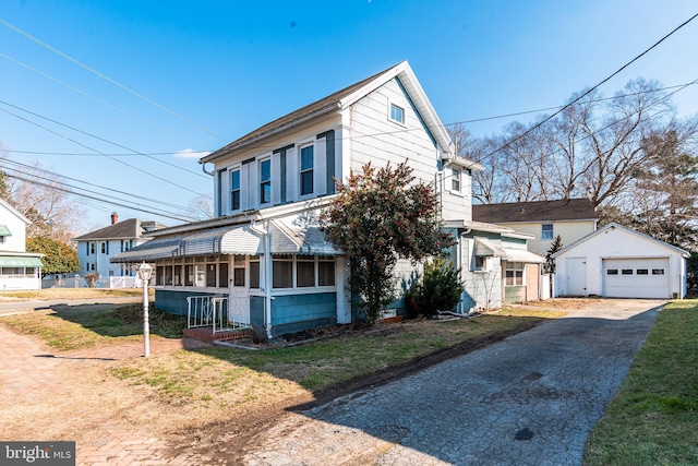 view of front property with a garage, an outdoor structure, covered porch, and a front lawn