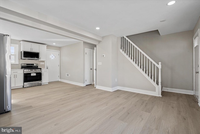 kitchen with white cabinetry, backsplash, stainless steel appliances, and light hardwood / wood-style floors