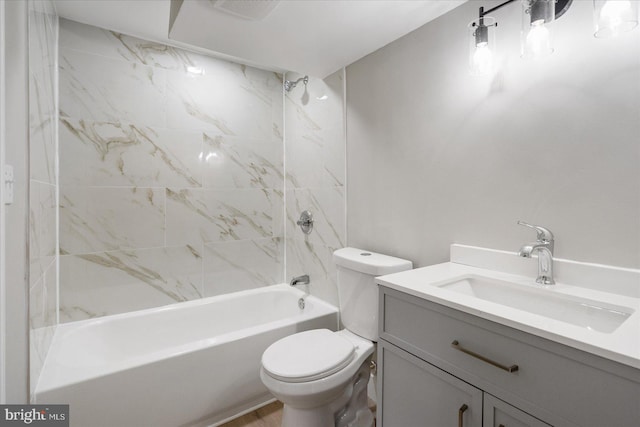 full bathroom featuring tiled shower / bath, vanity, and toilet