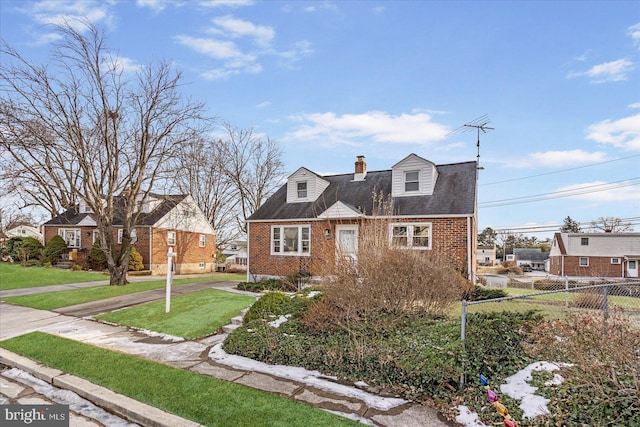 cape cod house featuring a front yard