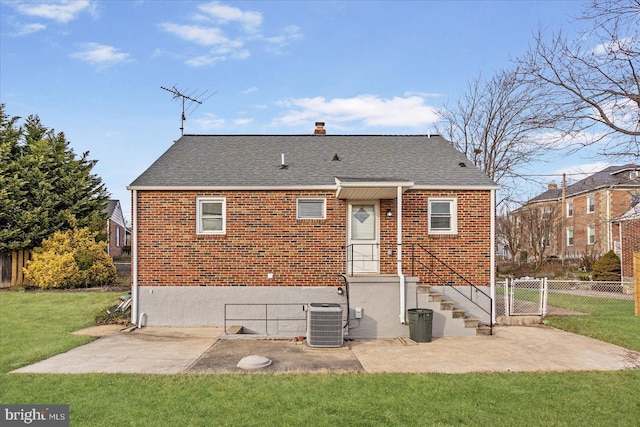 rear view of house with a patio, central AC unit, and a lawn