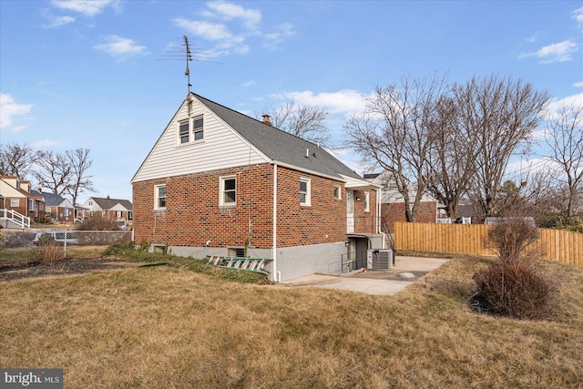 view of side of property with central AC unit, a yard, and a patio