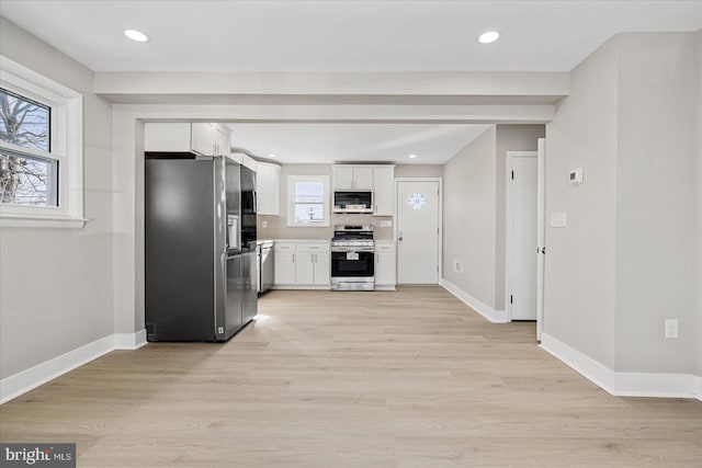 kitchen featuring tasteful backsplash, light wood-type flooring, white cabinets, and appliances with stainless steel finishes