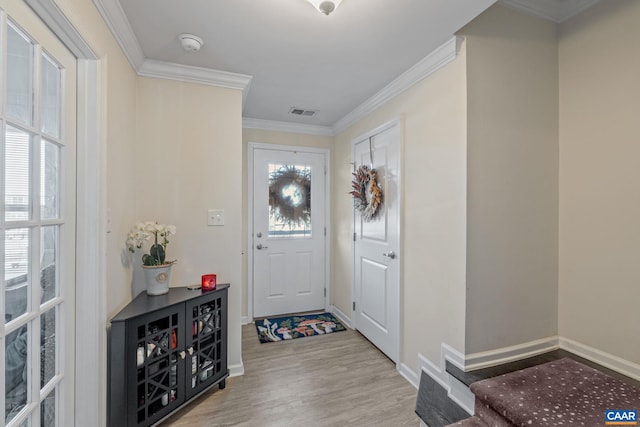 foyer entrance featuring crown molding and light wood-type flooring