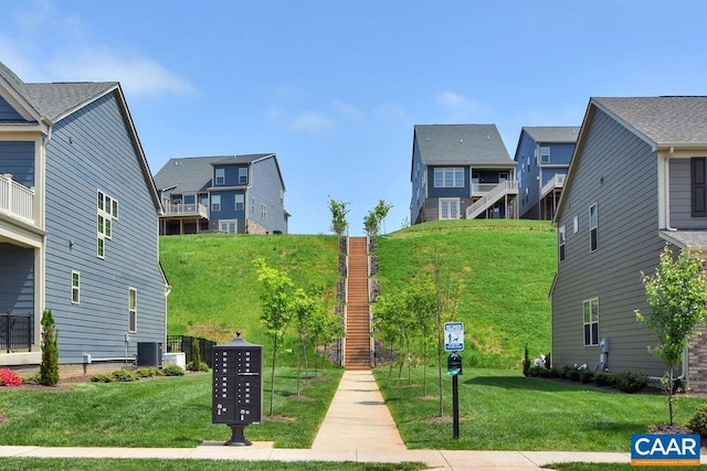 view of home's community featuring a mail area and a yard