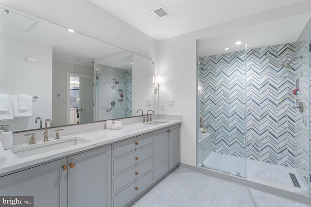 bathroom featuring a shower with door, vanity, and tile patterned flooring