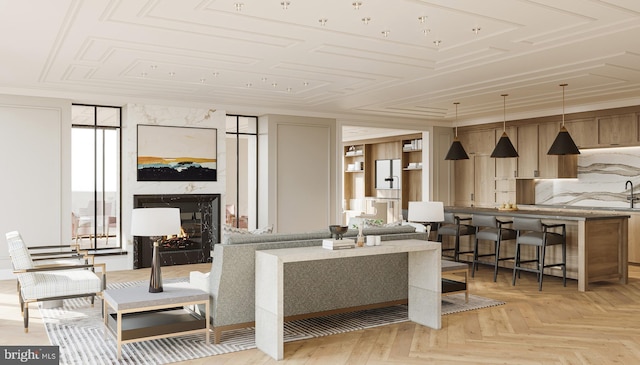 living room featuring crown molding, a fireplace, and light parquet floors