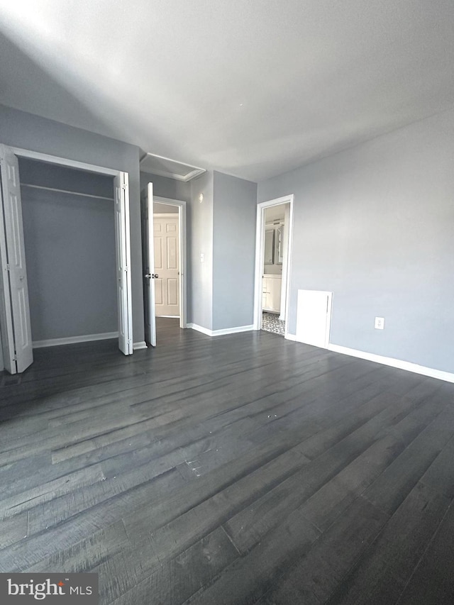 unfurnished bedroom featuring dark hardwood / wood-style flooring and a closet