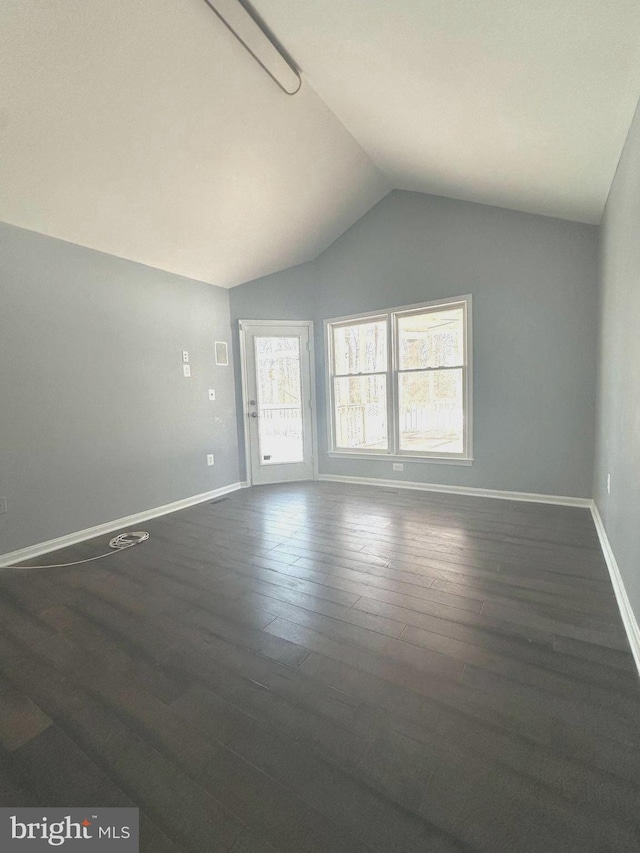 spare room featuring dark hardwood / wood-style floors and vaulted ceiling