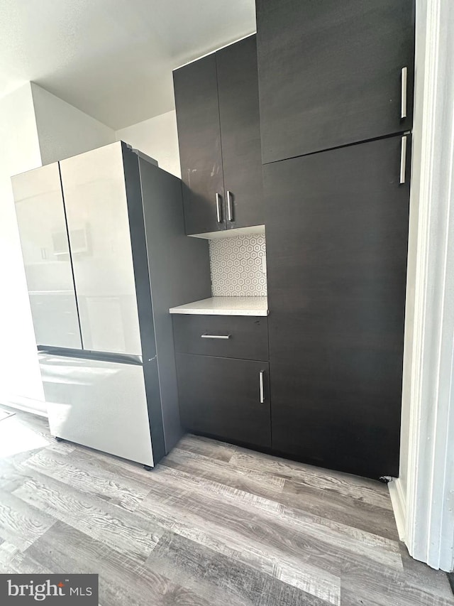 details with refrigerator, light hardwood / wood-style floors, and backsplash