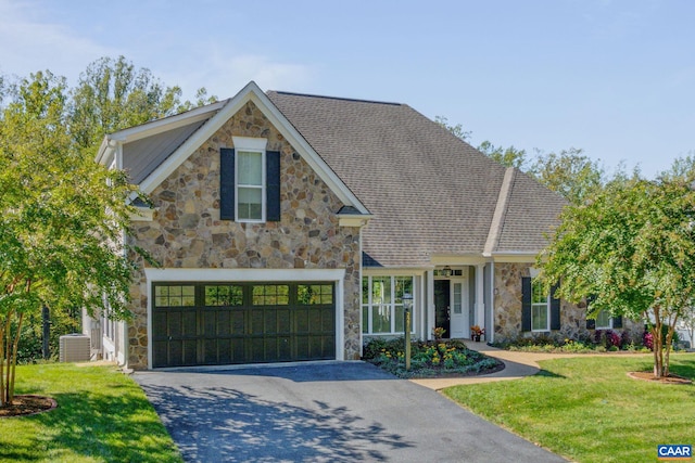 view of front of property with a garage, central air condition unit, and a front lawn