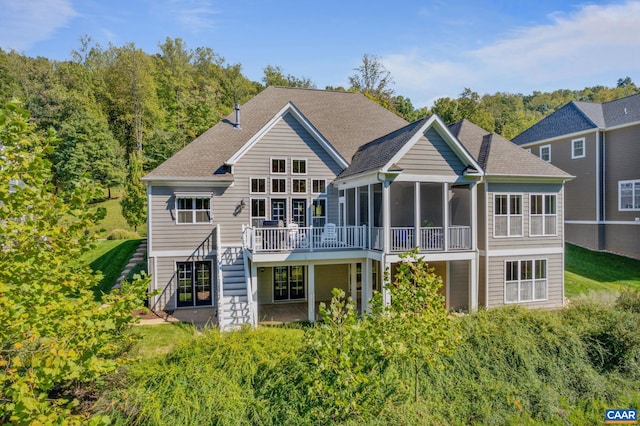 rear view of house featuring a sunroom and a wooden deck