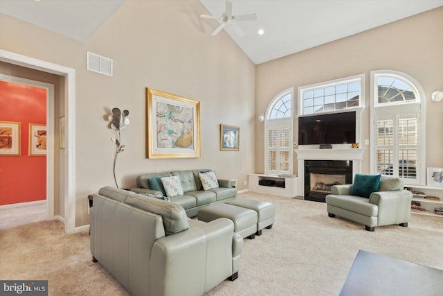 living room with ceiling fan, light colored carpet, and high vaulted ceiling