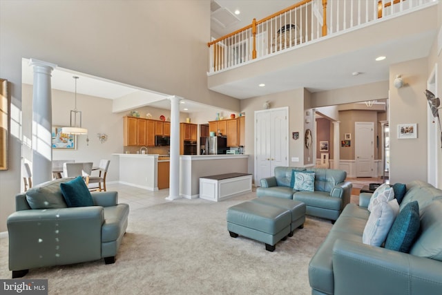 tiled living room with a towering ceiling and decorative columns