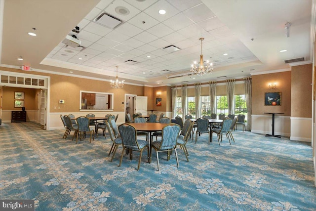 dining space with a raised ceiling, carpet, crown molding, and a chandelier