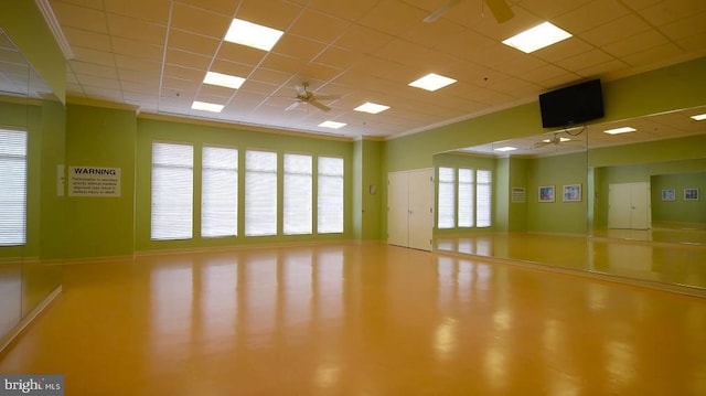 interior space featuring ceiling fan, crown molding, and a drop ceiling