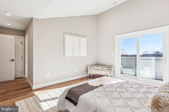 bedroom featuring light wood-type flooring and lofted ceiling