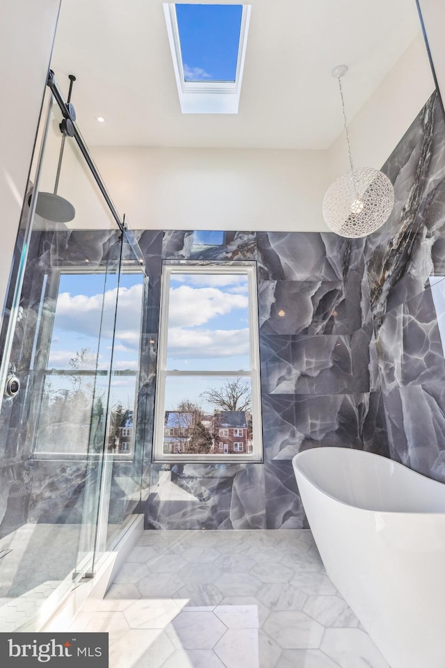 bathroom with a shower with shower door, tile walls, and a skylight