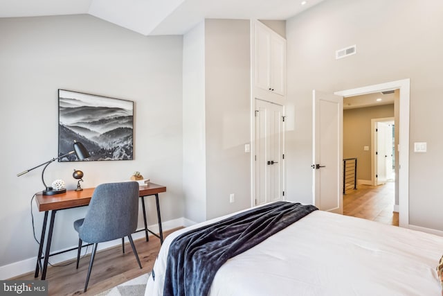 bedroom with light hardwood / wood-style flooring and lofted ceiling