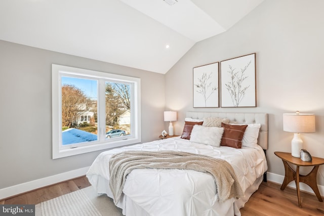 bedroom with lofted ceiling and wood-type flooring