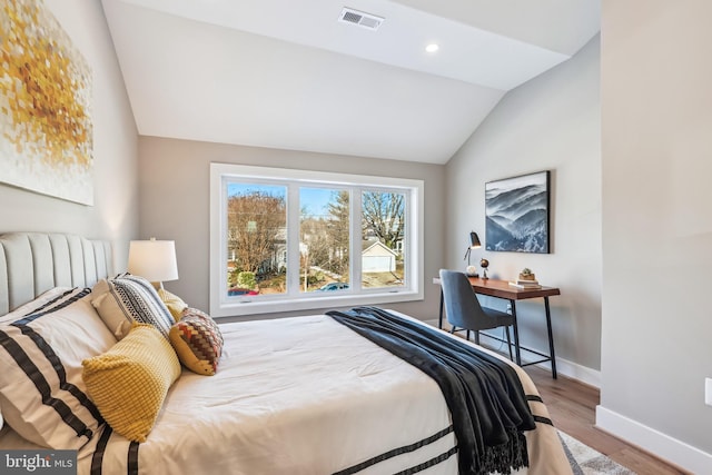 bedroom with lofted ceiling and wood-type flooring