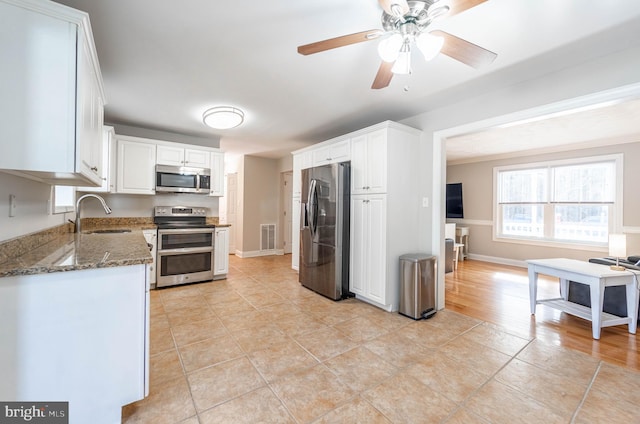 kitchen with white cabinetry, sink, dark stone counters, and appliances with stainless steel finishes