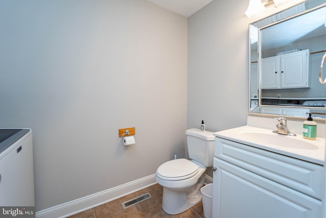 bathroom featuring vanity, tile patterned floors, and toilet