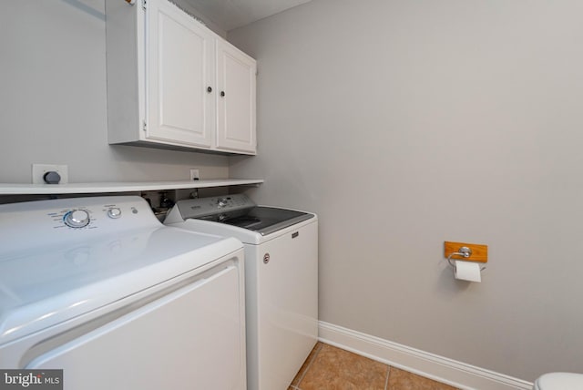 laundry area with cabinets, washer and dryer, and light tile patterned floors