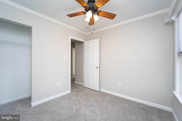 unfurnished bedroom with light carpet, crown molding, a closet, and ceiling fan