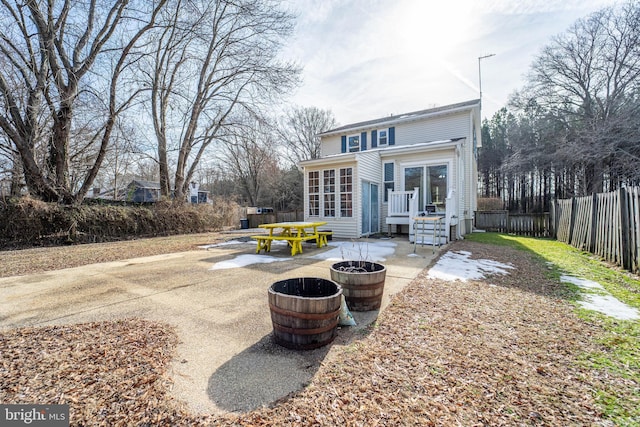 back of house with an outdoor fire pit and a patio