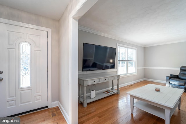 entryway featuring ornamental molding and light hardwood / wood-style flooring