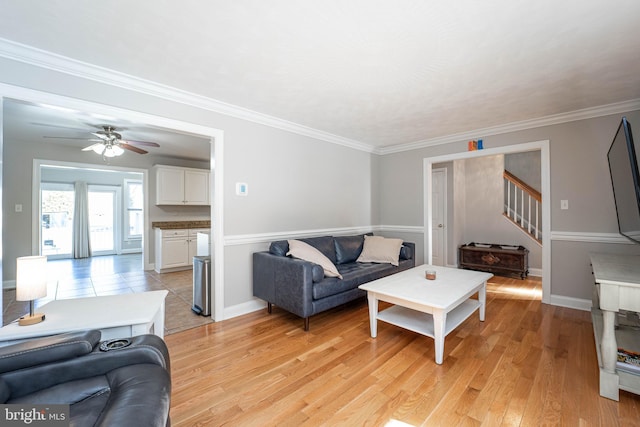 living room featuring ornamental molding, light hardwood / wood-style floors, and ceiling fan