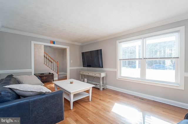 living room featuring ornamental molding and light hardwood / wood-style floors