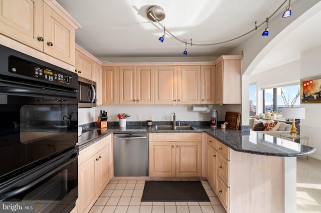 kitchen with sink, light brown cabinets, dark stone countertops, kitchen peninsula, and appliances with stainless steel finishes